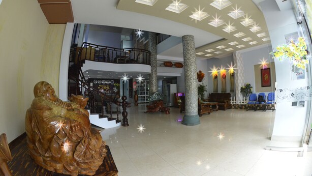 Eine geräumige Lobby mit hoher Decke, einer Treppe und einer Sitzecke.