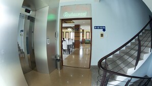 Eine Hotelhalle mit einem Schild für das 'White House Restaurant' und einer Treppe, auf der die Etagen B1 bis B4 gekennzeichnet sind.