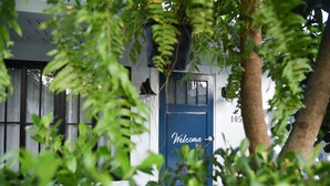 A building with a blue door marked "Welcome" and a number "105" on the wall.