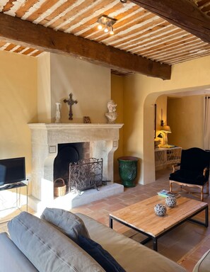 A living room with a fireplace, a sofa, a coffee table, and a television.
