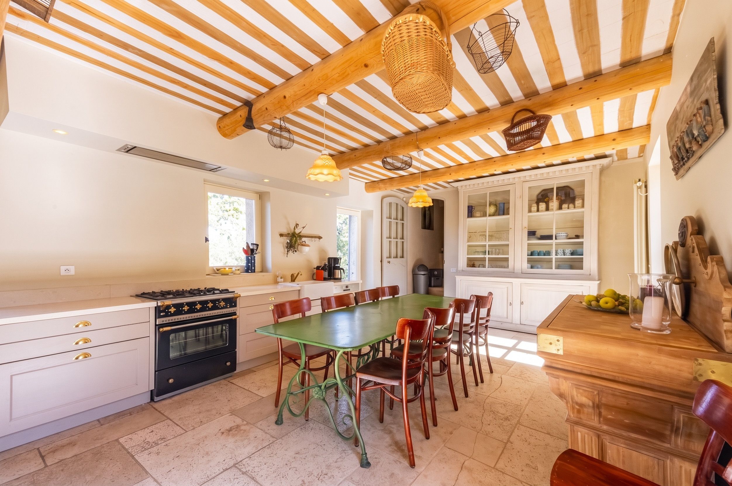 Una cocina con techo de madera, una mesa de comedor y sillas.