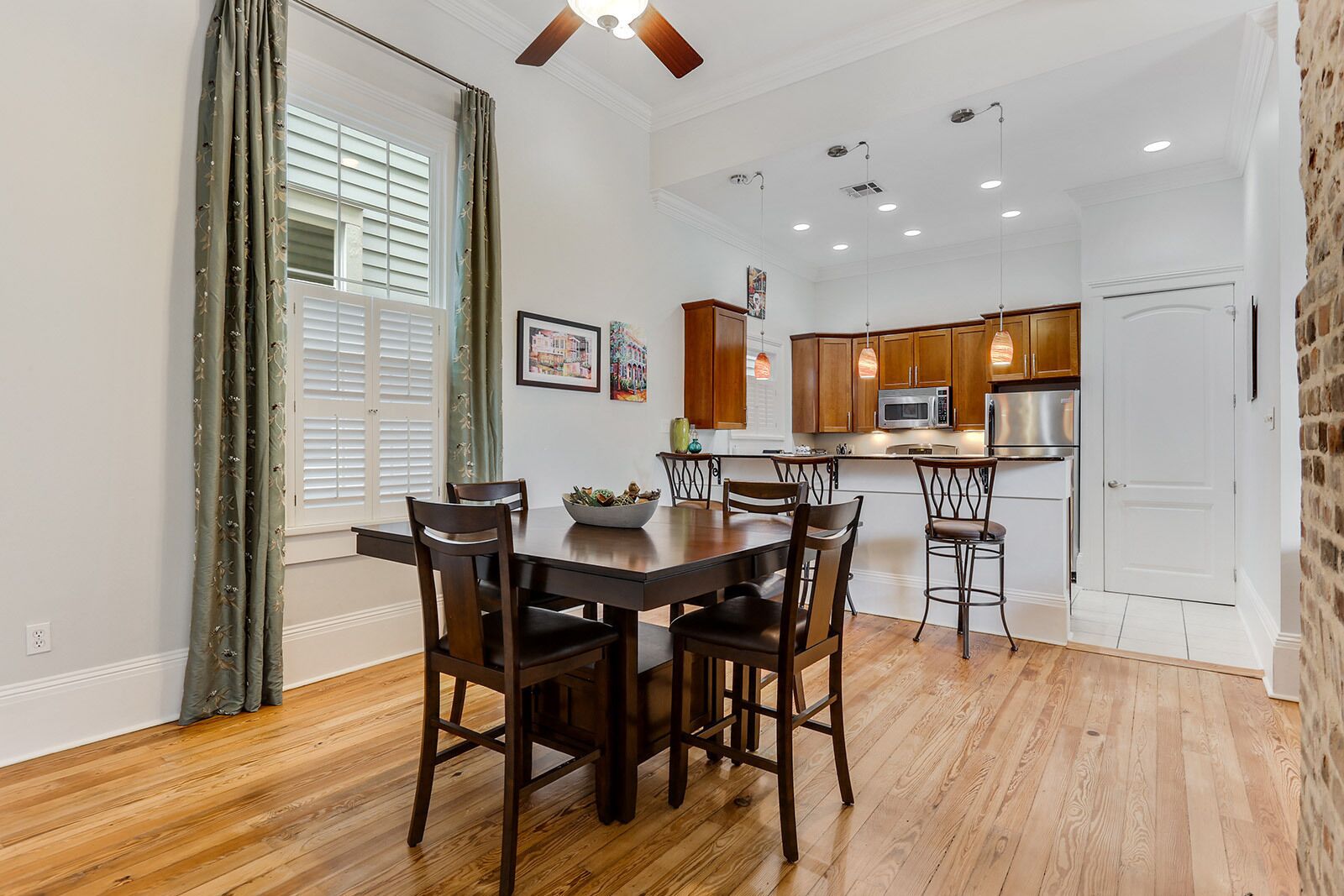 A modern kitchen with wooden cabinets, stainless steel appliances, and pendant lighting.
