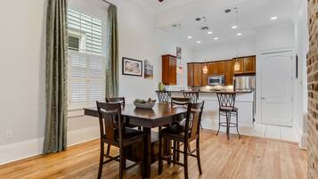 A modern kitchen with wooden cabinets, stainless steel appliances, and pendant lighting.