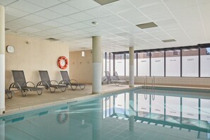 An indoor swimming pool with lounge chairs and a lifebuoy on the wall. - Appart de Montagne Cosy | Service de Navette ! (Serre Chevalier)