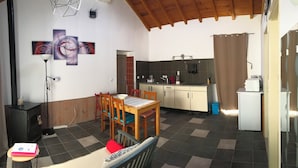 Une cuisine compacte comprenant un coin repas, une cuisinière noire et une table à manger avec des chaises.
