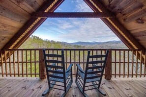 A wooden deck with two rocking chairs facing a scenic view of mountains and trees. - Amazing Views from this 3 bedroom cabin located on the peaceful side of the Smoky Mountains Hot Tub (Townsend)