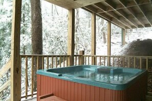 Eine Holzterrasse mit Whirlpool.