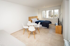 Enjoy a comfortable stay in this stylish room with a neatly made bed, dining table, and city view.