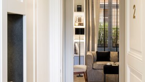 A hallway leading to a living area with a sofa, a coffee table, and a bookshelf. - Residenza B (Rome)