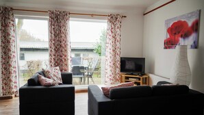 A living room with two sofas, a TV, and a dining area with a table and chairs. - Vacation apartment Rosenstube - Lindenhof (Steinberg)