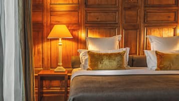 Ein Hotelzimmer mit einem großen Bett, einem Nachttisch, einer Lampe und einem Spiegel.