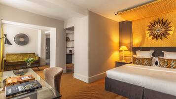 Une chambre d’hôtel comprenant un lit, un bureau avec une lampe, un canapé et un élément décoratif mural.