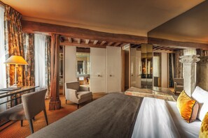 A hotel room with a bed, a desk, a chair, a mirror, and a view of the bathroom. - Lion d'Or 1774 - Châteaux de la Loire (Romorantin-Lanthenay)