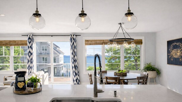 A modern kitchen with a large island, stainless steel sink, and pendant lighting. - Mar Azul \ Walk to the Beach \  Enjoy Ocean Views \  Near Newport (Middletown)