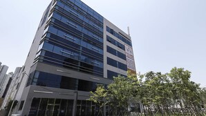 En moderne hotelbygning med flere etager, store vinduer og et skilt, der angiver, at det er et hotel.