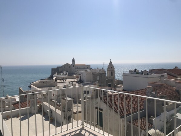 Eine Küstenstadtlandschaft mit Gebäuden, einer Kirche und freiem Blick auf das Meer.
