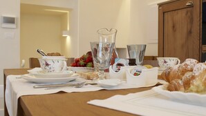 A breakfast table set with plates, cups, a pitcher, and pastries. - Estlevante B&B (Vieste)