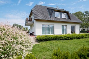 A modern two-story house with a sloped roof, a balcony, and large windows. - Modern apartment only 300m to the Baltic Sea beach - apartment with balcony (Heringsdorf)
