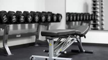 A gym with a bench and dumbbells.