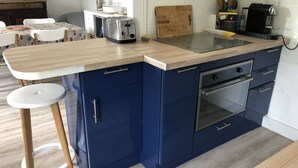 A kitchen with a wooden countertop, blue cabinets, a toaster, and a coffee maker. - La Cabane de pêche de la Cotinière (Saint-Pierre-d´Oléron)