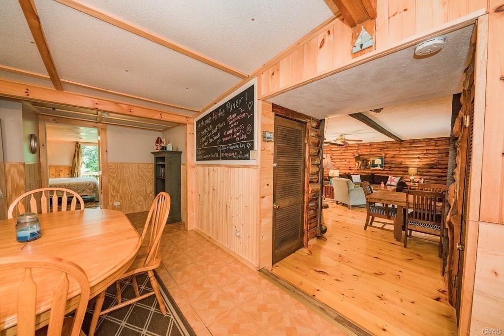 Interno di una baita in legno con zona pranzo, cucina e soggiorno.