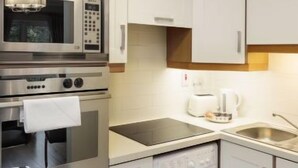 A compact kitchen with a built-in oven, microwave, and dishwasher.