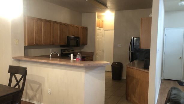 A compact kitchen with wooden cabinets, a microwave, a sink, and a refrigerator. - Fetokai Suite Inn, this is a beautiful home and suites with your vacation (Arlington)