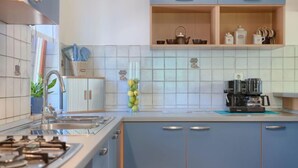 A modern kitchen with blue cabinets, a gas stove, and a coffee maker. - Vacation home Corina by Interhome (Medulin/Šišan)