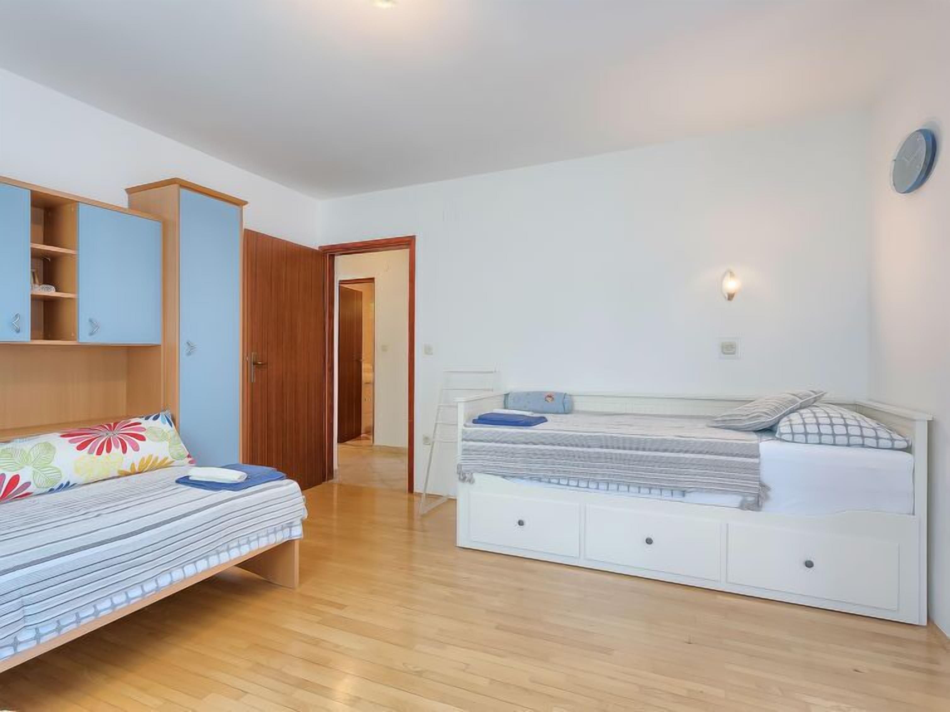 A bedroom with a bed, a wardrobe, and a desk.