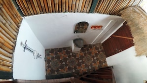 Un escalier en colimaçon avec des marches en bois et un plafond en bambou.