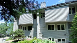 A two-story building with a brick pathway leading to the entrance.