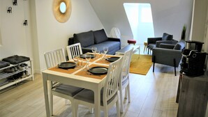 A modern loft apartment with a dining area, a gray sofa, and a coffee machine. - Apartment center Rouen (Rouen)