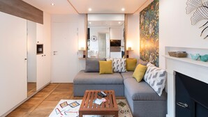 A modern living room with a grey sofa, wooden coffee table, and a fireplace. - Le Petit Botté - Studio plein cœur de Rennes (Rennes)