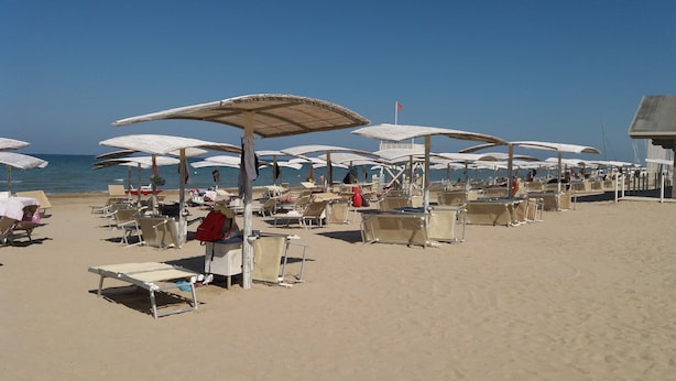 A beach with rows of sun umbrellas and lounge chairs. - Oasi dei Vandali, small and cozy residence in the historic center, 5 min from the sea (Mondolfo)