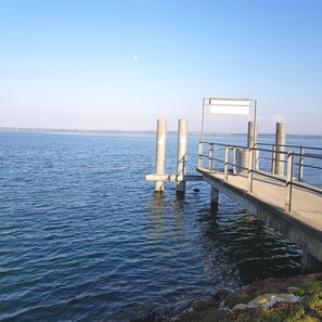 Un muelle se adentra en aguas tranquilas bajo un cielo despejado.