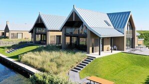 Un complexe résidentiel moderne composé de plusieurs maisons dotées de toits inclinés et de grandes fenêtres.