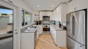A modern kitchen with stainless steel appliances, a built-in oven, and a microwave. - Ocean view easy access to Doran Beach, Golf  course and  Bluewater Bistro. (Bodega Bay)