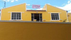 A yellow building with a sign that reads "Lua Rosa" and a phone number.