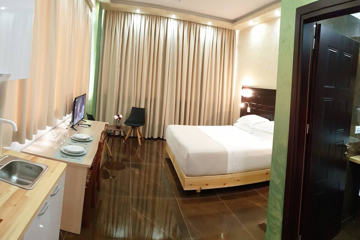 Une chambre d’hôtel comprenant un lit, une petite kitchenette, un coin repas et une salle de bain.