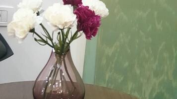 Una mesa redonda de madera con un jarrón de flores.