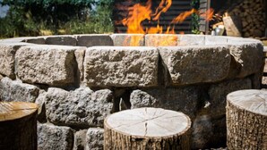 Ein Steinkamin mit Holzscheiten und Feuer.