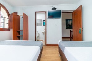 A hotel room with two beds, a TV, wooden wardrobe, and a bathroom visible through an open door. - Ayenda Palermo Plaza (Bogotá)