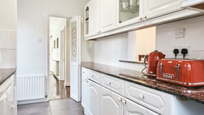A kitchen with white cabinets, a granite countertop, and a red toaster. - 16 Austin Avenue (Bromley)