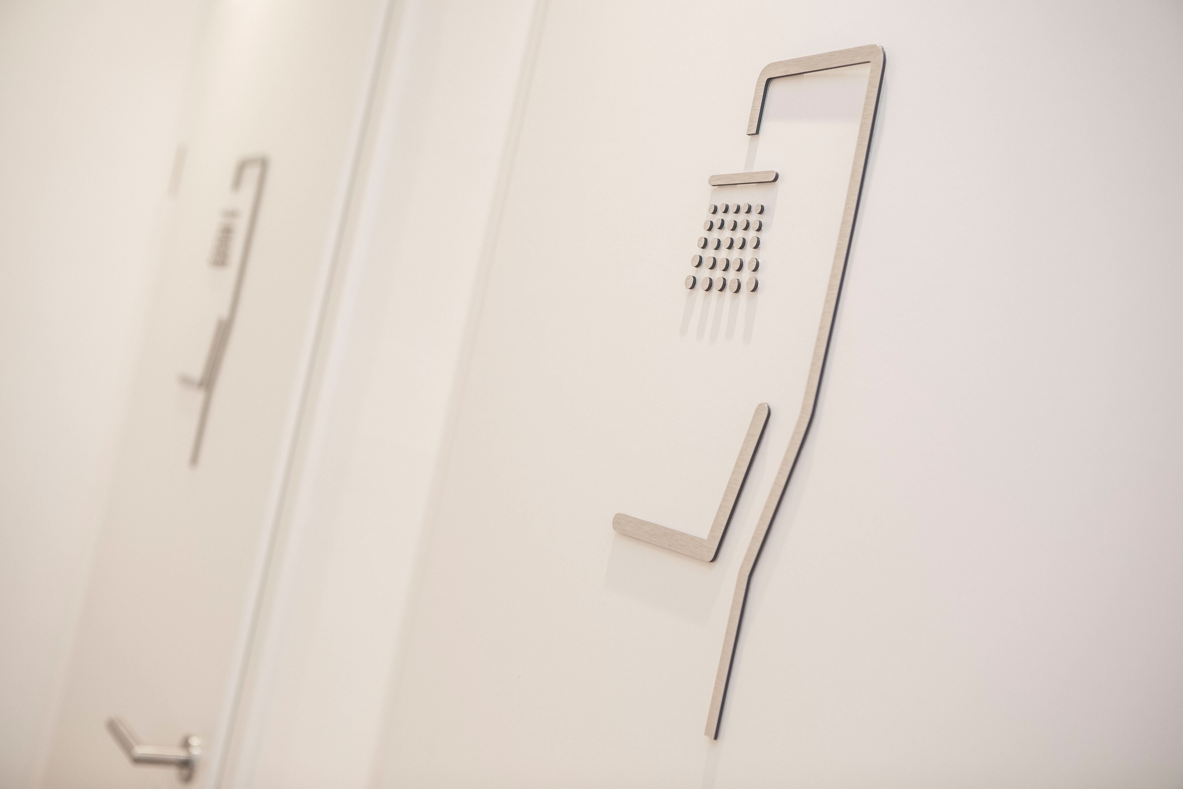 Une salle de bain moderne au design minimaliste, dotée d’une douche murale avec une seule manette et d’une série de jets circulaires.