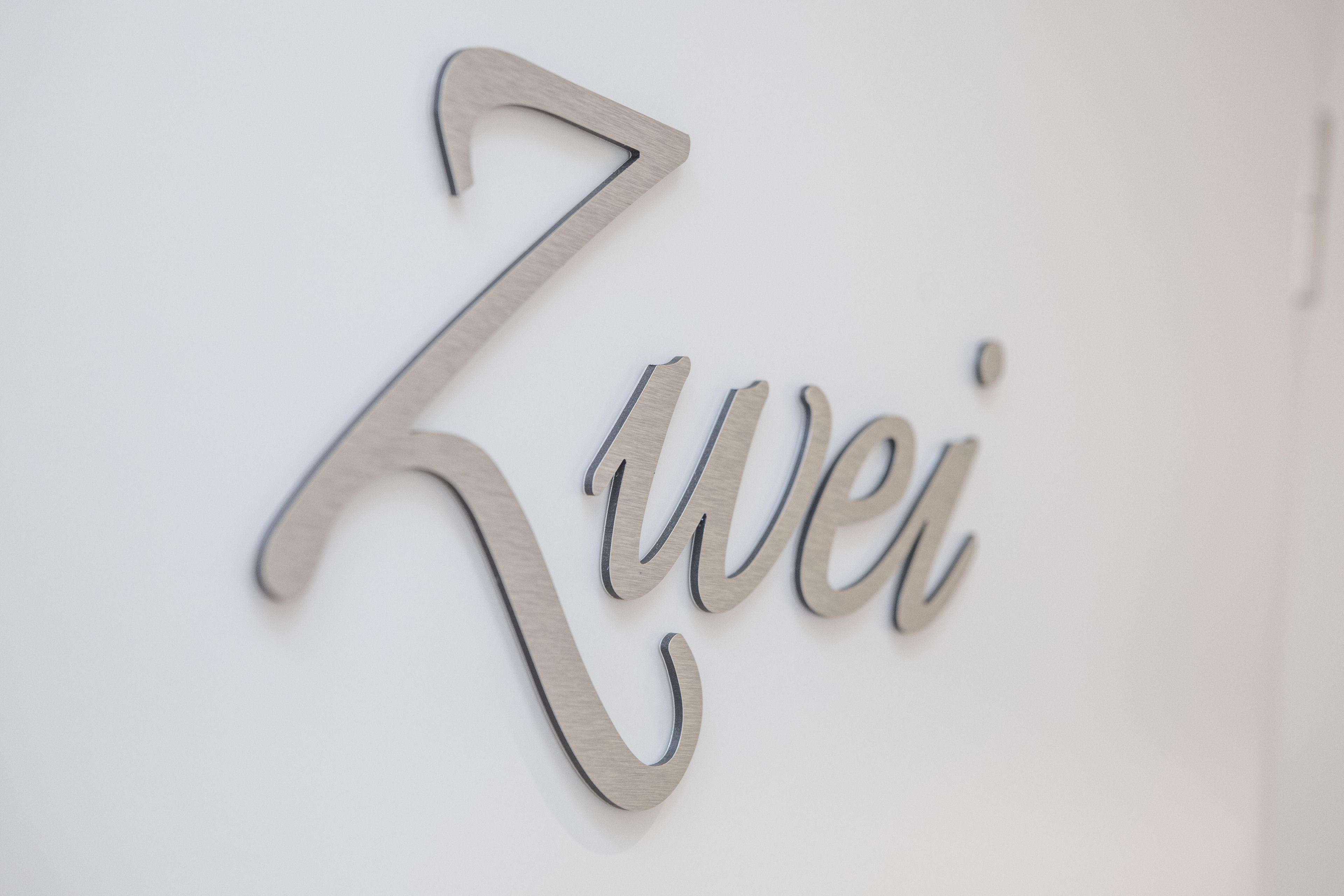 Una pared con un letrero metálico que dice "Zwei".