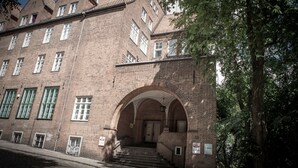 A historic building with a symmetrical facade, multiple windows, and a central arched entrance.
