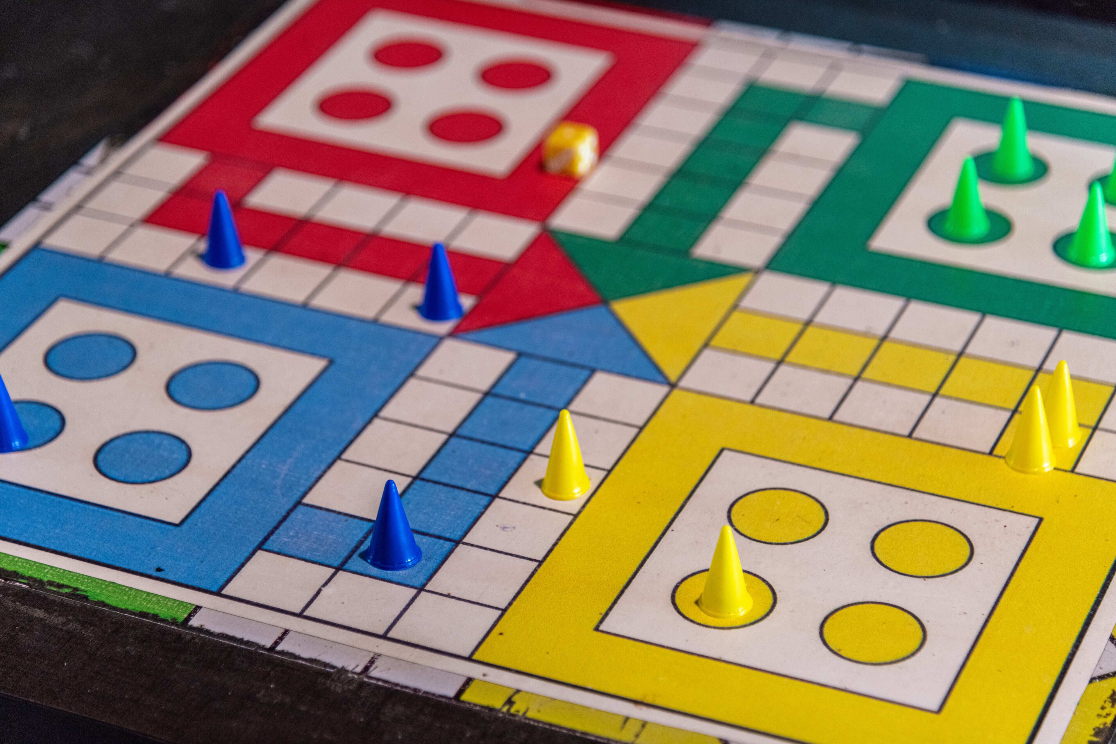 Ein Detailbild eines Spielbretts mit bunten Feldern und Spielfiguren.