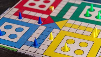 Ein Detailbild eines Spielbretts mit bunten Feldern und Spielfiguren.