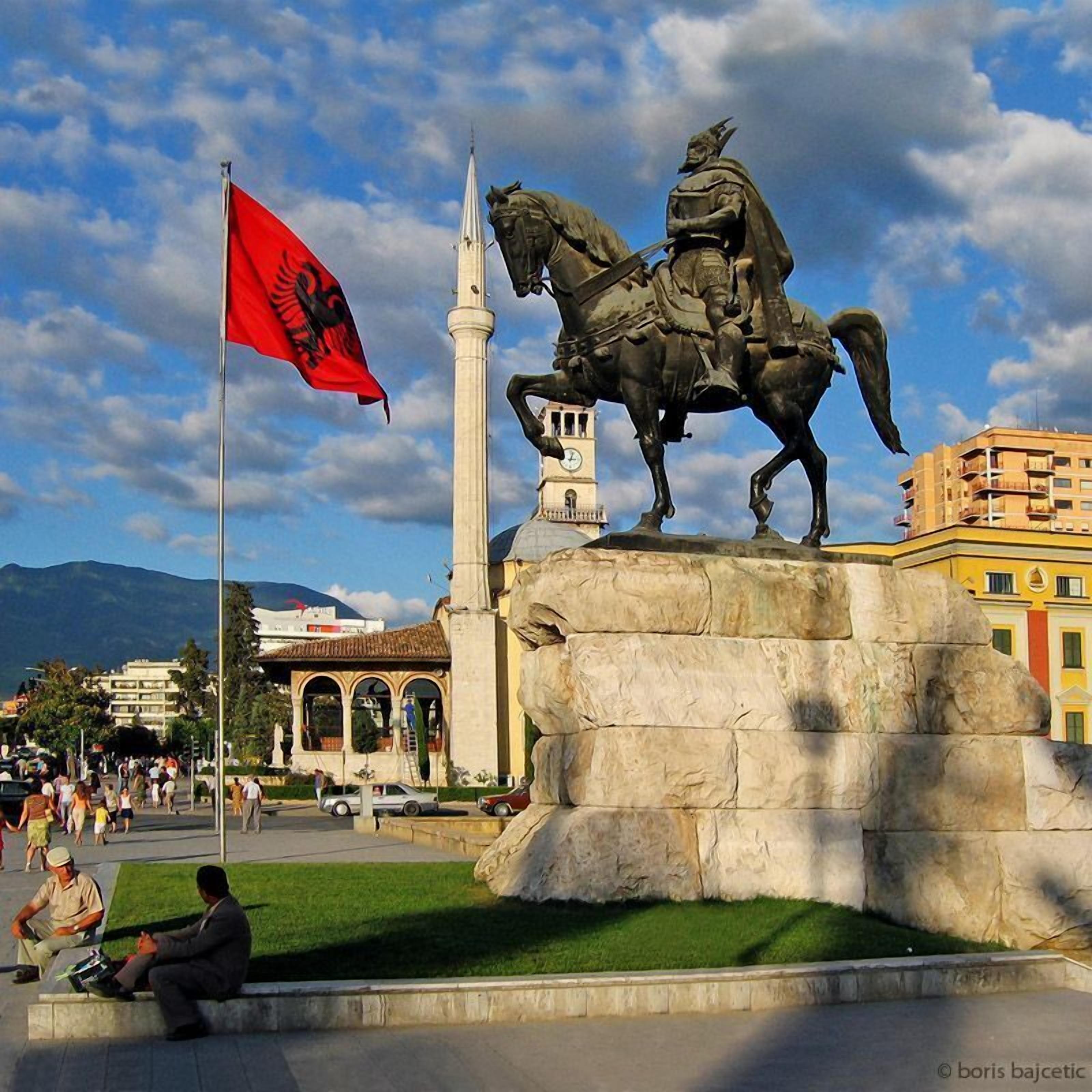 A statue of a man on horseback with a flagpole in the foreground.
