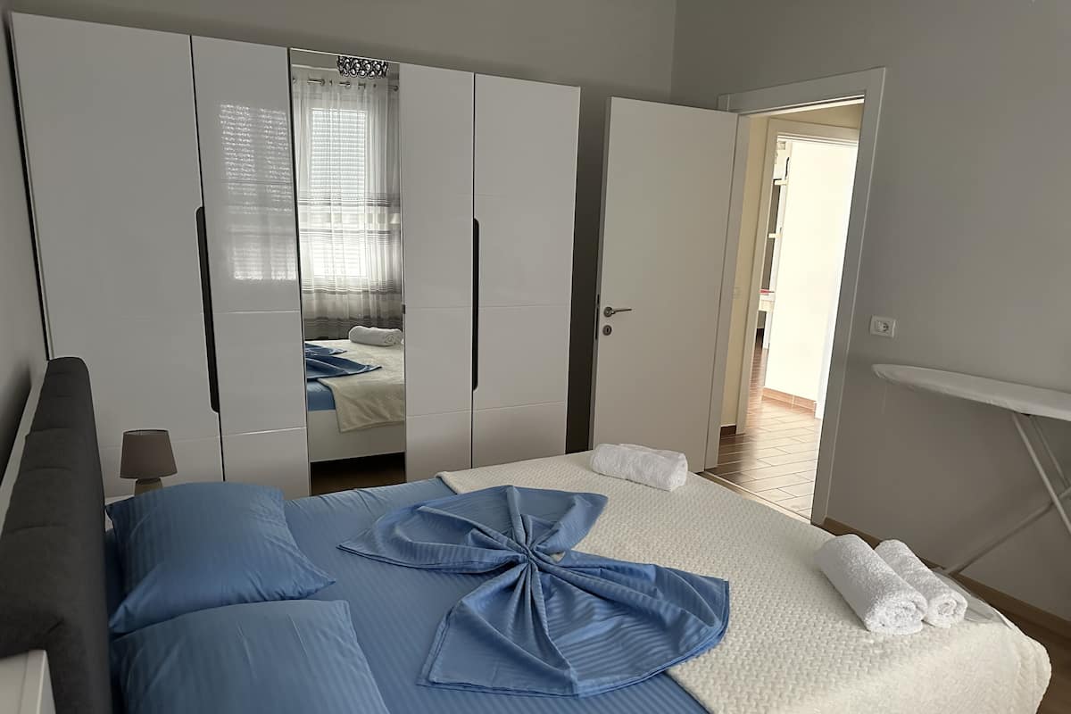 Een slaapkamer met een bed, een kledingkast en een spiegel.